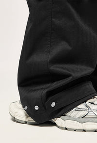 Black wide-leg pants with snap closures.