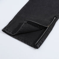 Black denim jeans with ankle zipper.