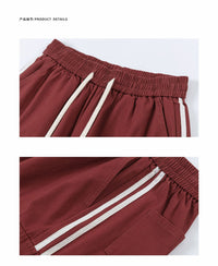 Maroon athletic pants with white stripes.