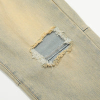 Distressed denim jeans with patched hole.