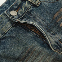 Distressed denim jeans with zipper.
