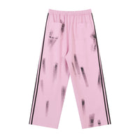 Pink wide-leg pants with black stripes and brushstroke pattern.