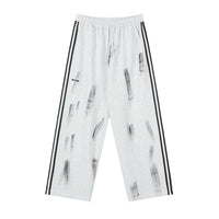 White wide-leg sweatpants with black stripes.